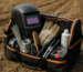 kit mentenanță sudură teren cu mască, electrozi și consumabile pe fundal agricol