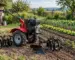 Motocultor cu accesorii folosit într-o gospodărie pentru pregătirea solului și întreținerea grădinii