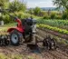 Motocultor cu accesorii folosit într-o gospodărie pentru pregătirea solului și întreținerea grădinii