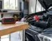 redresor cu funcție de pornire auto conectat la bateria unei mașini în garaj