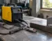 Invertor de sudură folosit într-un atelier, alături de electrozi și piese metalice