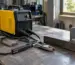 Invertor de sudură folosit într-un atelier, alături de electrozi și piese metalice