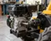 Motor pe benzină de 15 CP montat lângă un utilaj mic, cu axul și prinderile vizibile