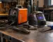 Aparat de sudură cu invertor pentru lucrări grele într-un atelier, alături de electrozi și accesorii