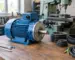 Motor electric monofazat 4 kW montat într-un atelier, lângă un utilaj și componente de transmisie