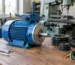 Motor electric monofazat 4 kW montat într-un atelier, lângă un utilaj și componente de transmisie