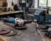 Polizor unghiular 125 mm pe banc de lucru într-un atelier, alături de discuri și echipament de protecție