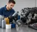 Tehnician care compară uleiul potrivit pentru utilaje și motoare într-un atelier