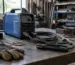 invertor MMA 400A într-un atelier de sudură, lângă cabluri și piese metalice